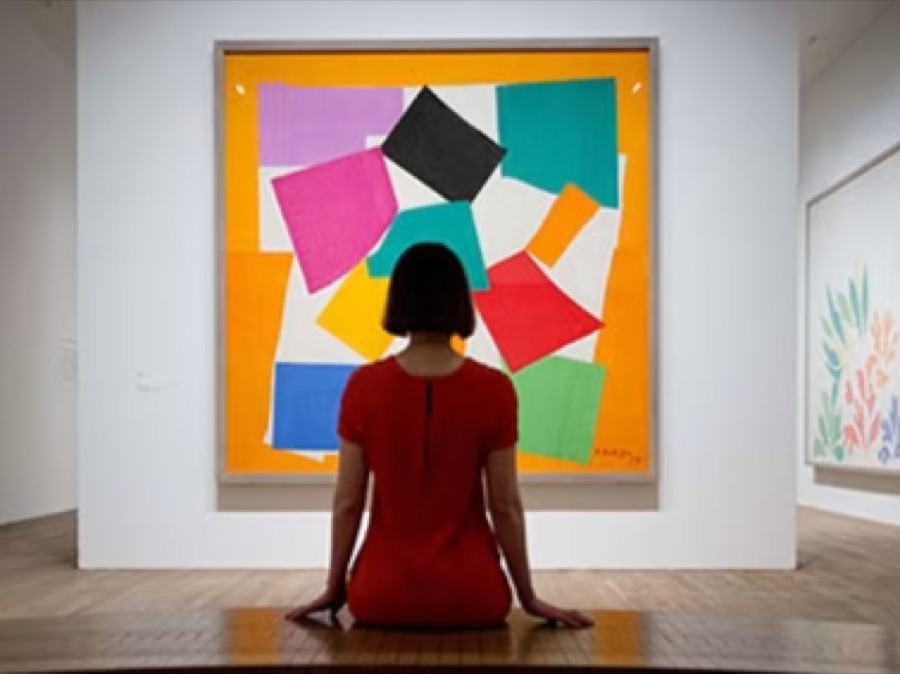 Visitor seated before a large modernist cut-out composition